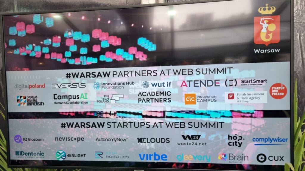 Plansza przedstawiająca nazwy i loga polskich firm obecnych na Web Summit w Lizbonie. Czytając od góry:
logo Warszawy, napis "Warsaw partners at web summit", logo partnerów, napis "Warsaw startups at web summit", loga startupów